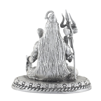 Silver statue of a shiva with a long hair and traditional attire on a white background