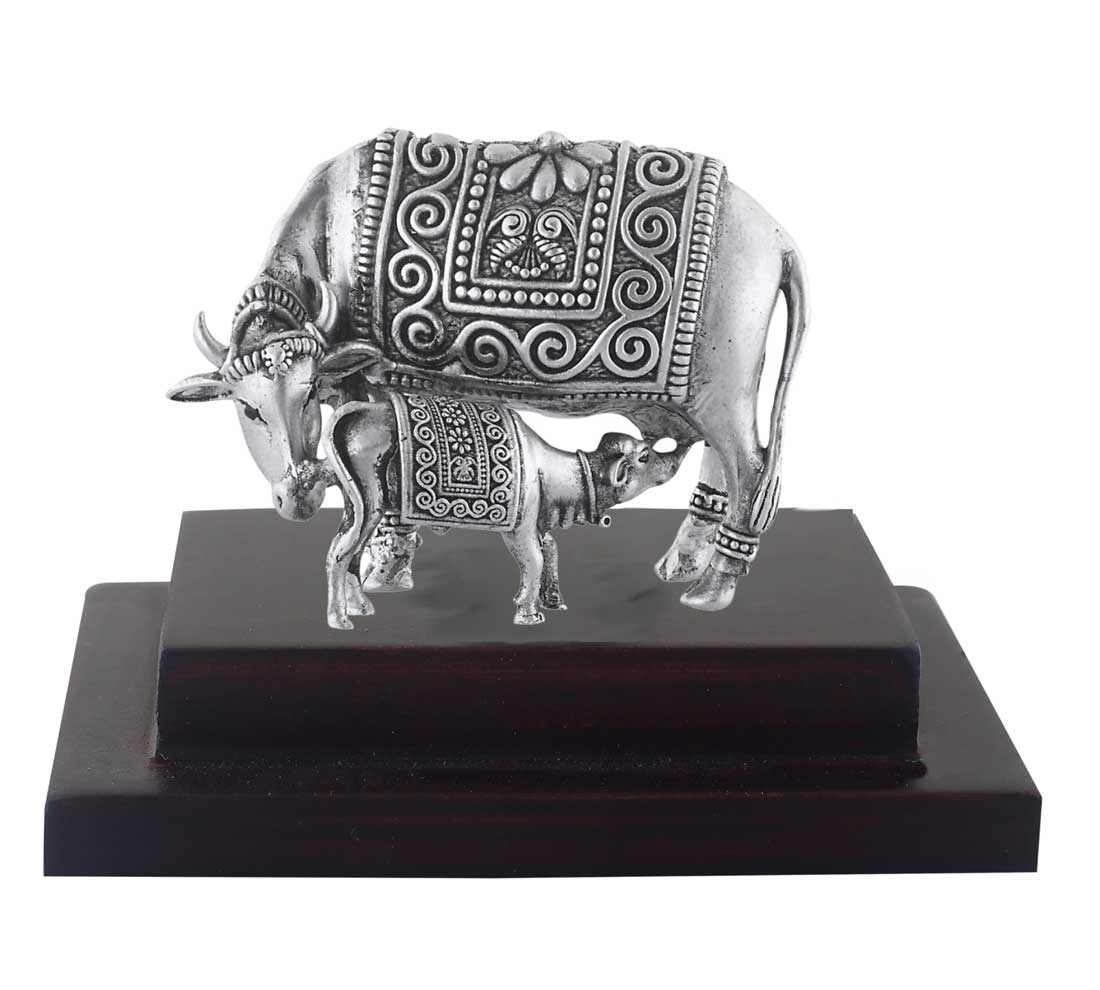 silver cow on wooden base